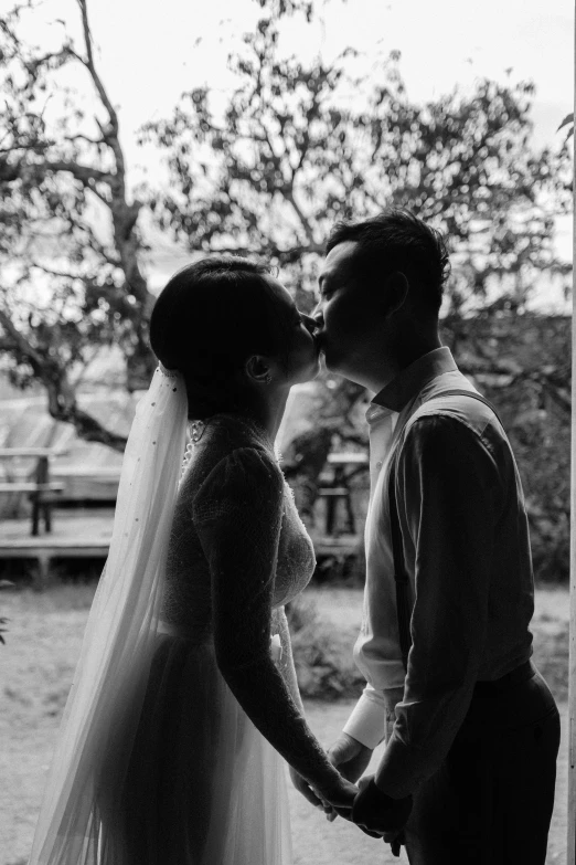 a man and woman standing next to each other near trees