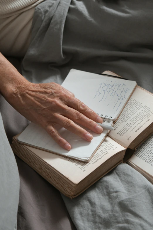 an elderly woman holding an opened book and a cigarette