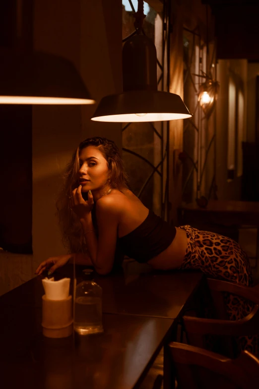 a young woman leaning on a bar counter, talking on the phone