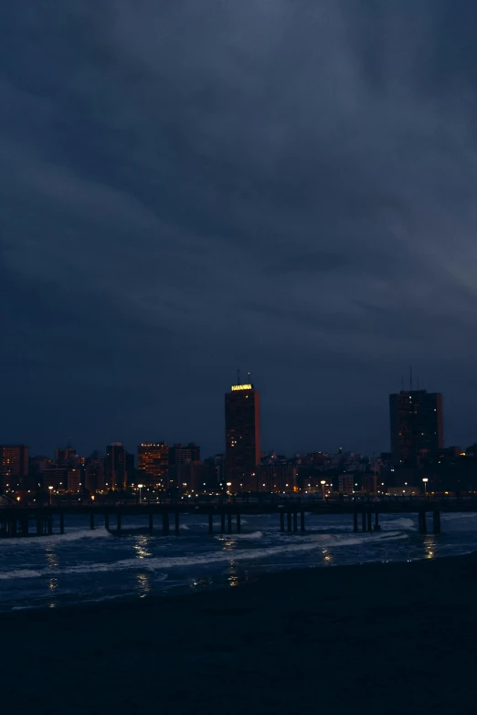 a full moon seen rising over a city across the water