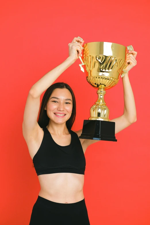 a woman is holding up a trophy trophy