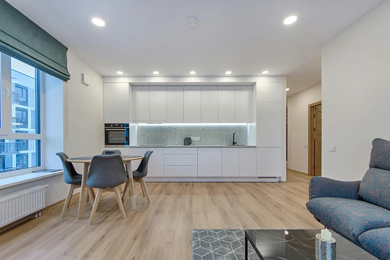 a modern apartment has white cabinets and a wooden floor