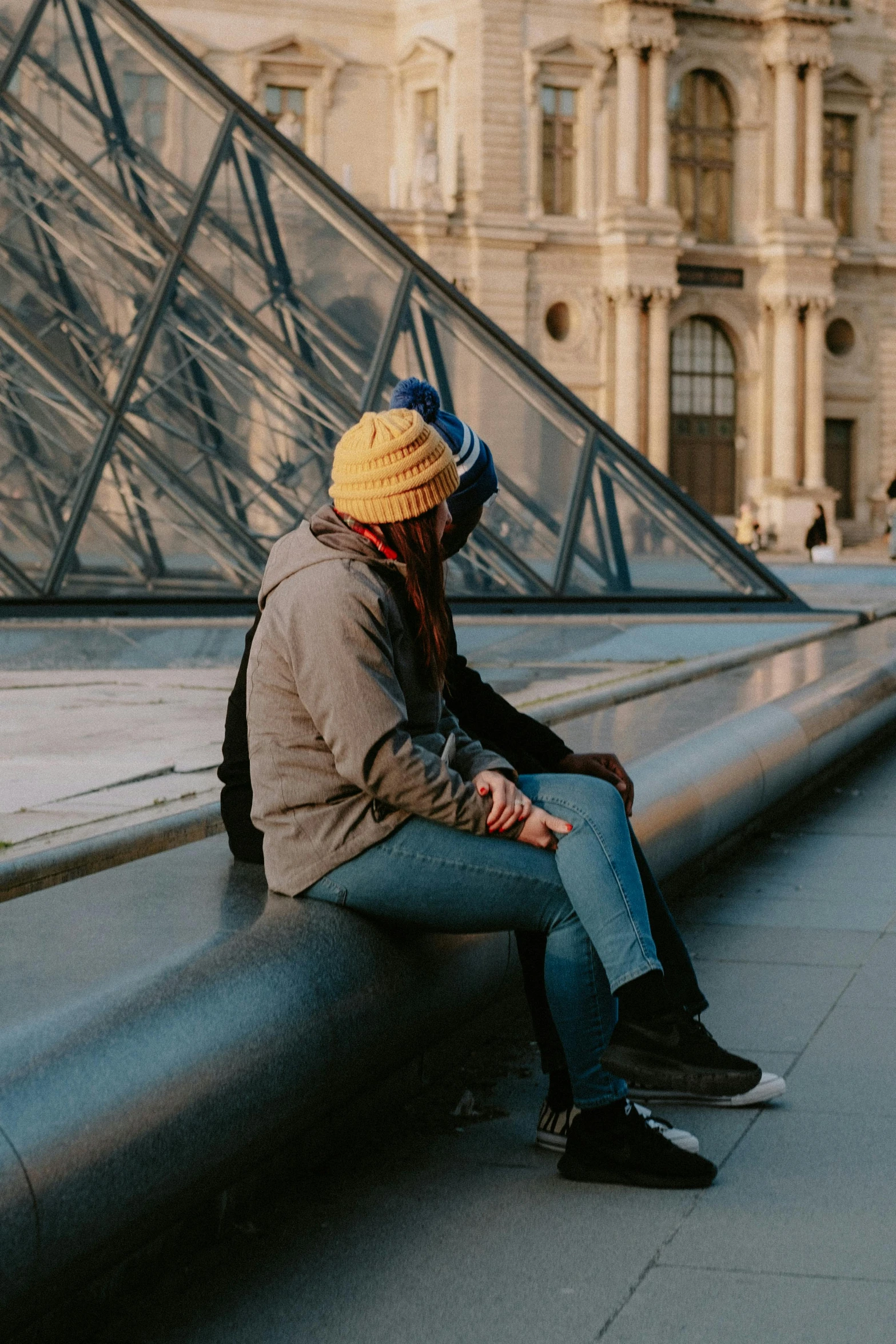 a girl is sitting down on a ledge