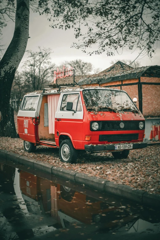 a van parked in front of a brick building near a body of water