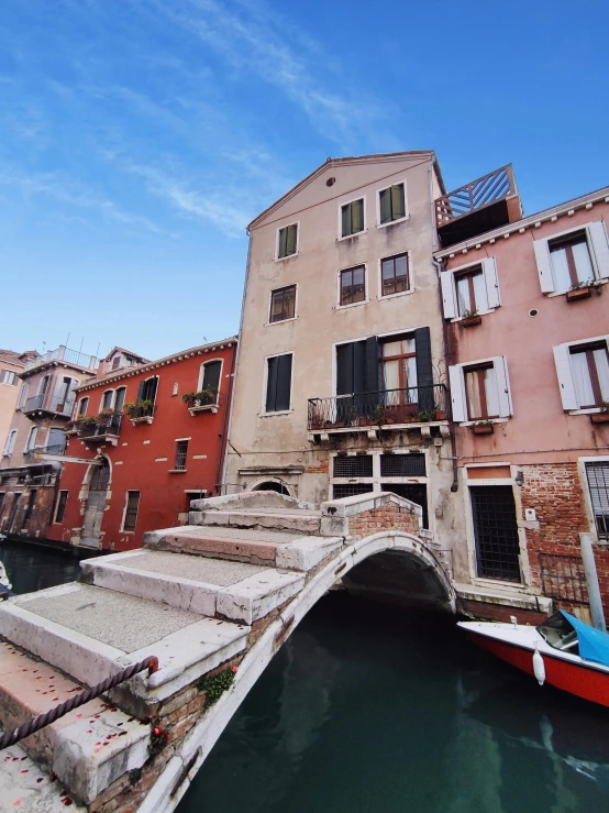 a canal scene with an old bridge and small boats