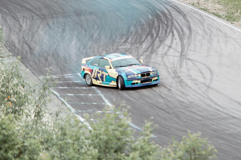 a blue race car with a white and red emblem