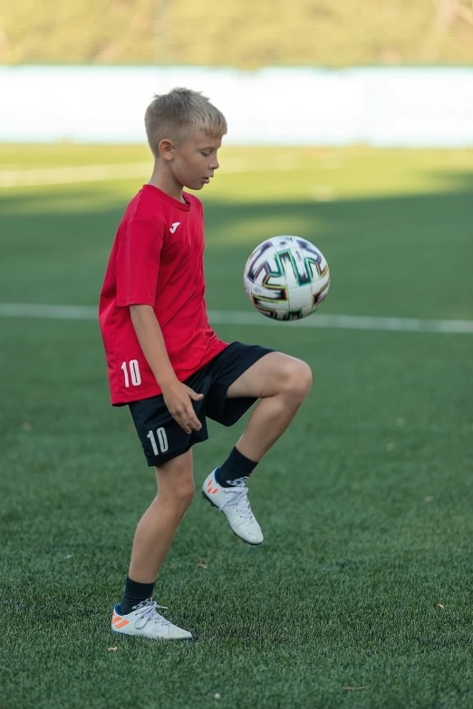 a little boy is about to kick a soccer ball