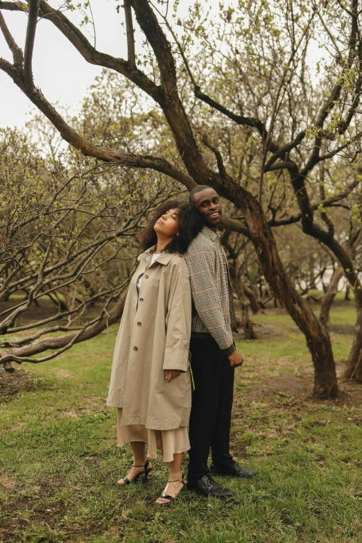 a man and woman looking up at soing while standing in the grass