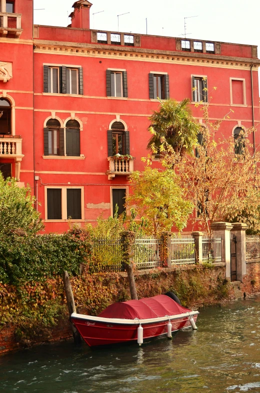 there is a boat in front of a building and trees