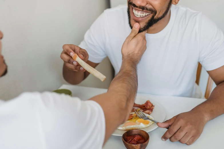 a man eating food while holding a knife and fork