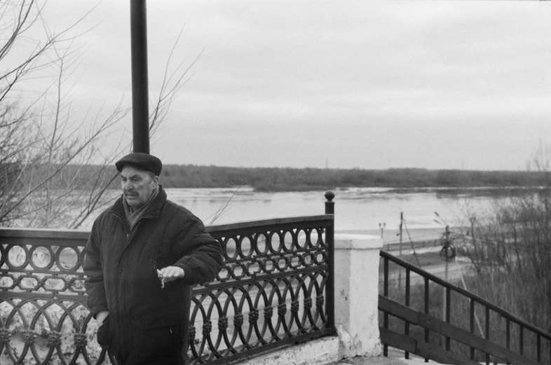 a man leaning on a rail by the water