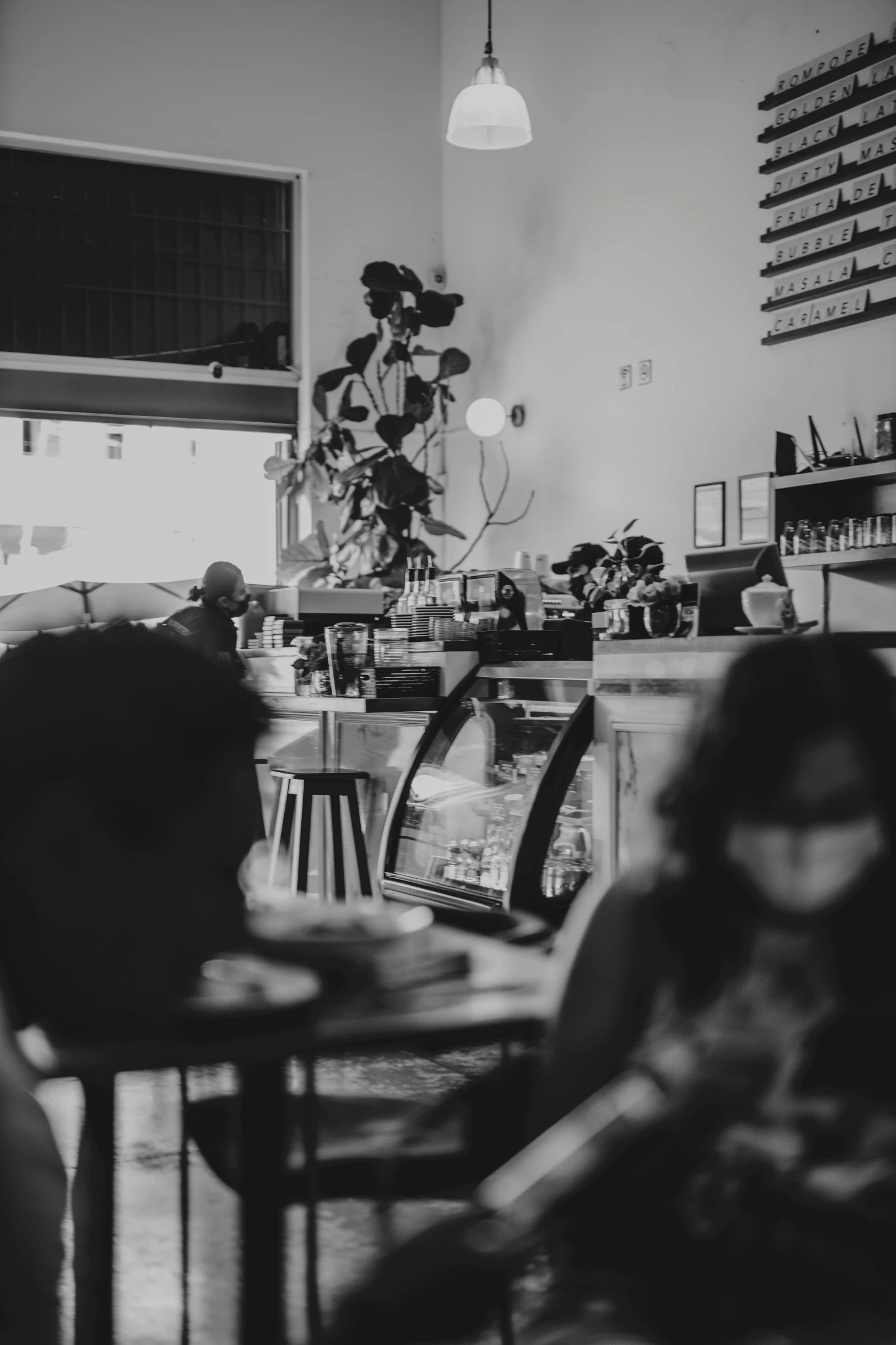 two people sitting at a restaurant table with an open laptop computer on it