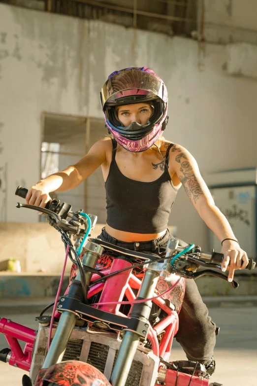 a woman wearing helmet sitting on pink motorbike