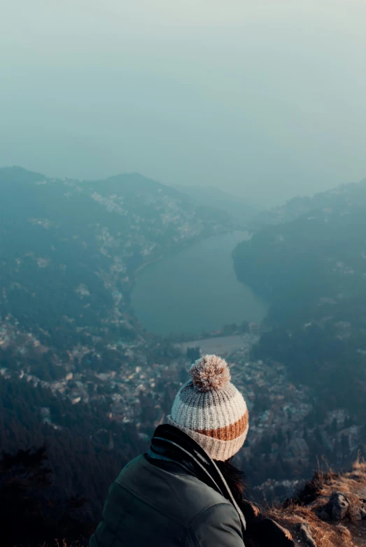 a person is standing on a mountain looking down