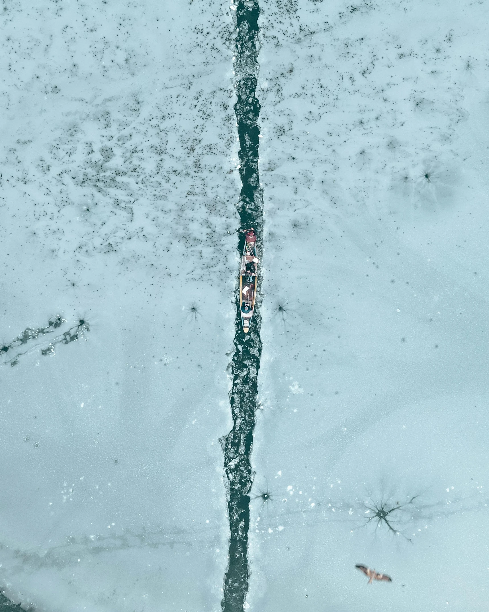 a red fire hydrant sitting next to a patch of water