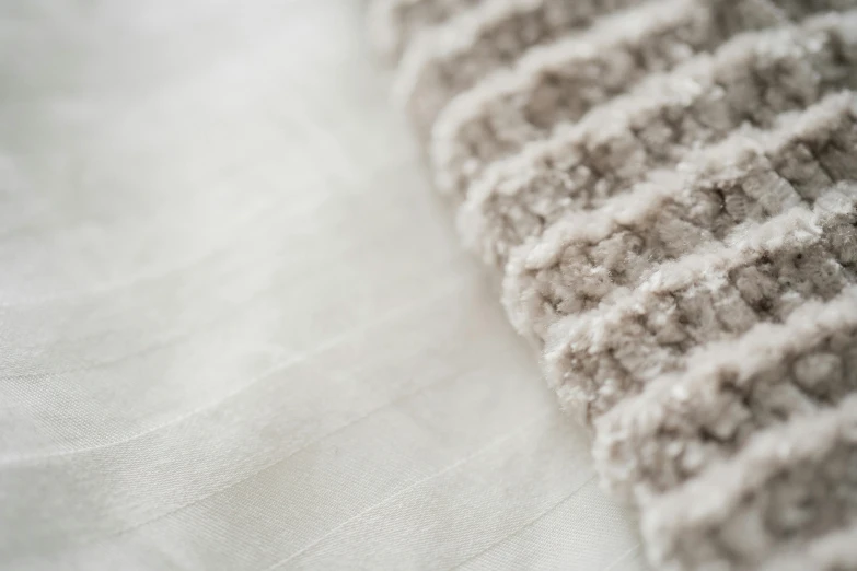 a close up of a white and brown bed sheet