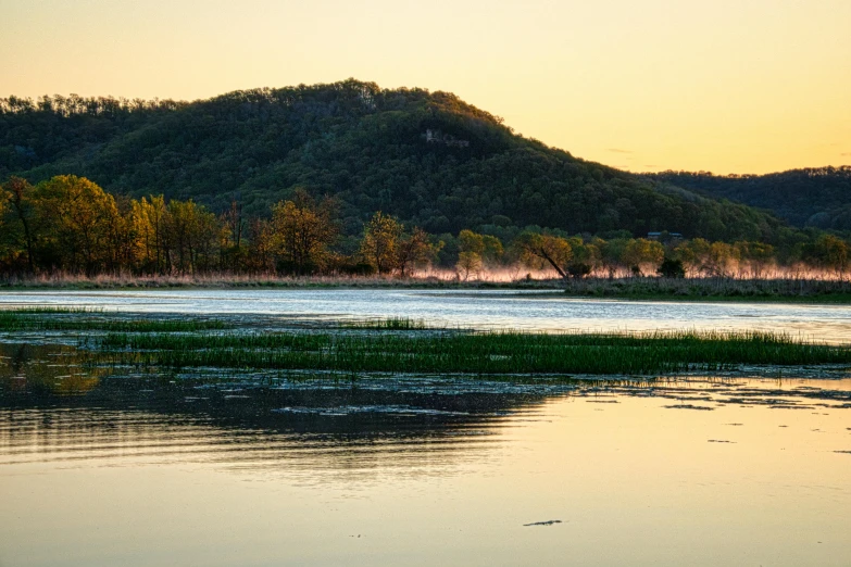 the reflection of a hill in the water of a lake