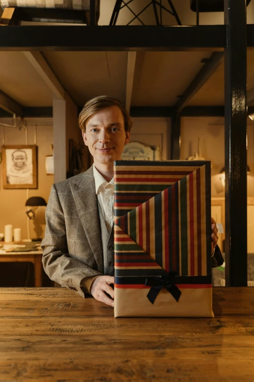 a man holding a brown wrapped present near a bar