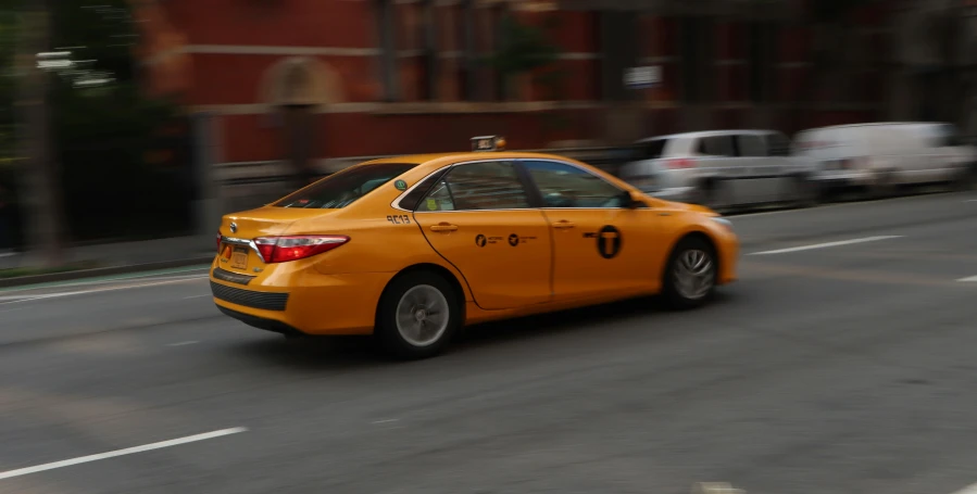 a yellow taxi cab driving down the street