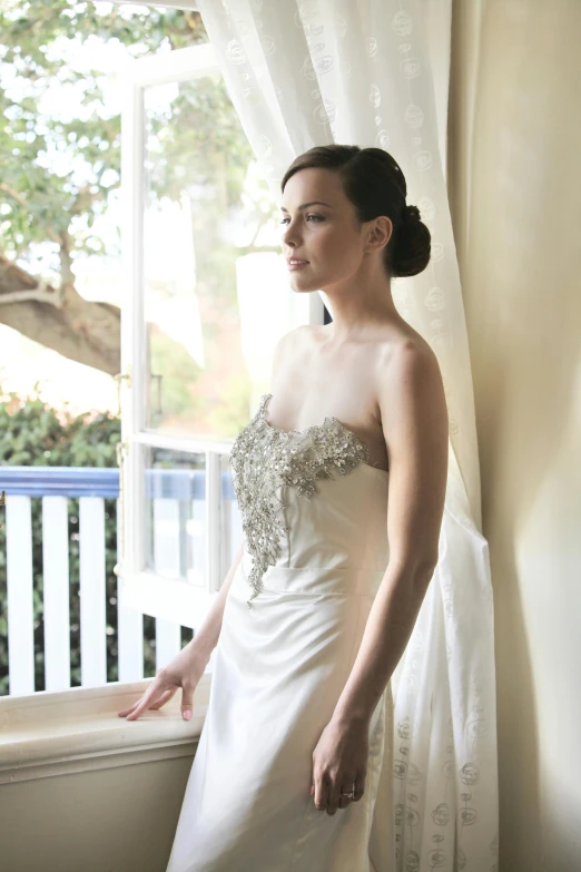 a woman in a white dress looking off into the distance