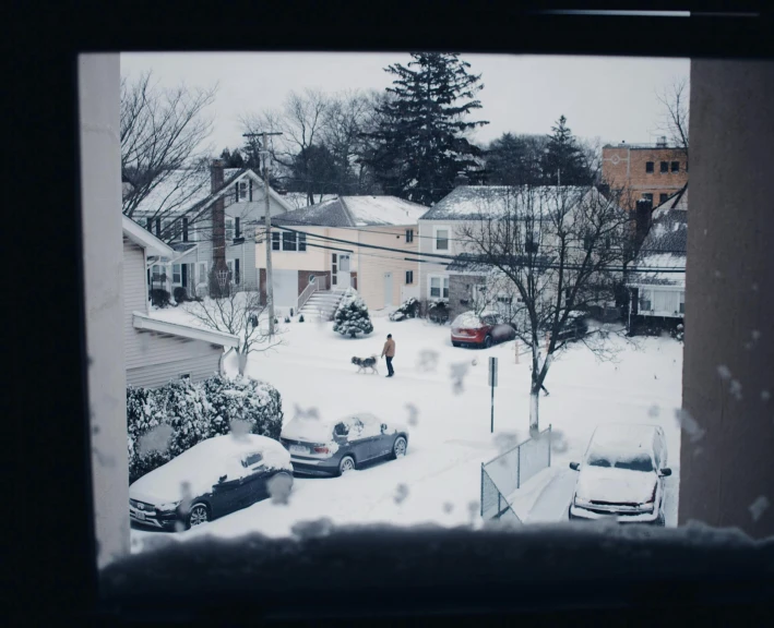 looking out at the snowy houses through a window