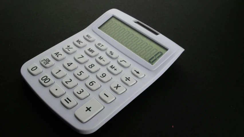 a calculator sits on a black surface