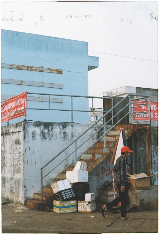 a man carrying boxes down the steps outside a building