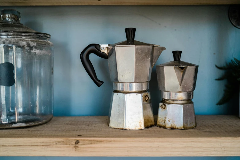 there is some silver coffee makers on the shelf