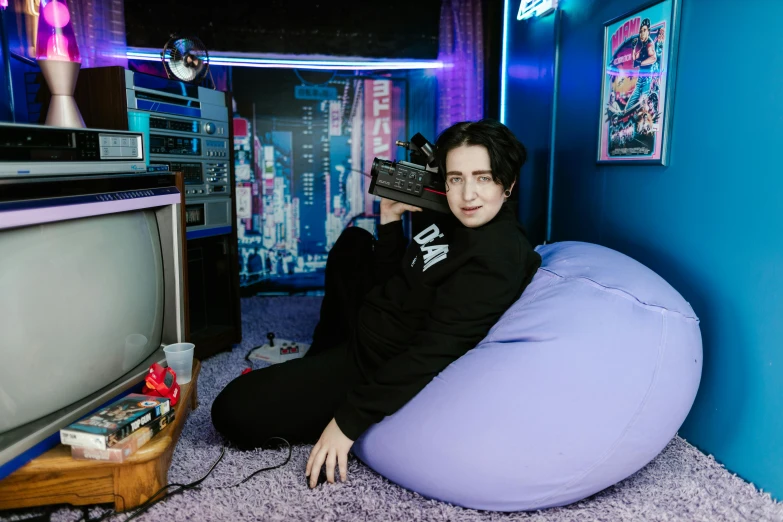 a woman sitting on a bean bag chair in front of a tv