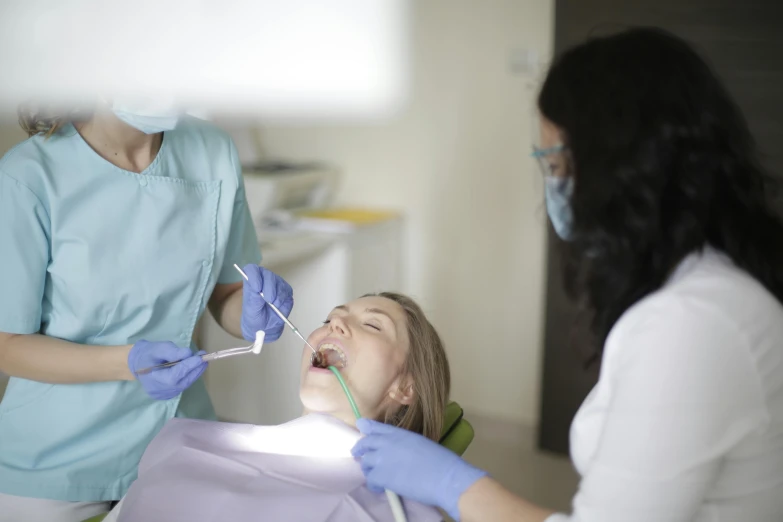 a girl at a dentist is preparing to brush her teeth