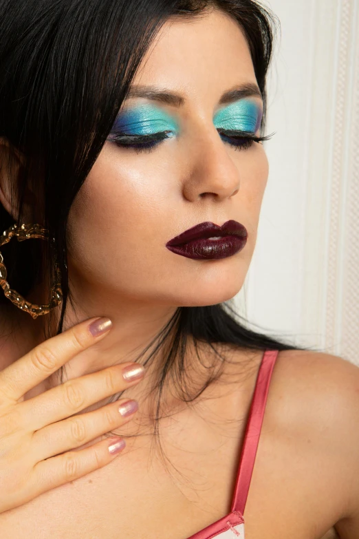 a woman with a multicolored makeup looks down