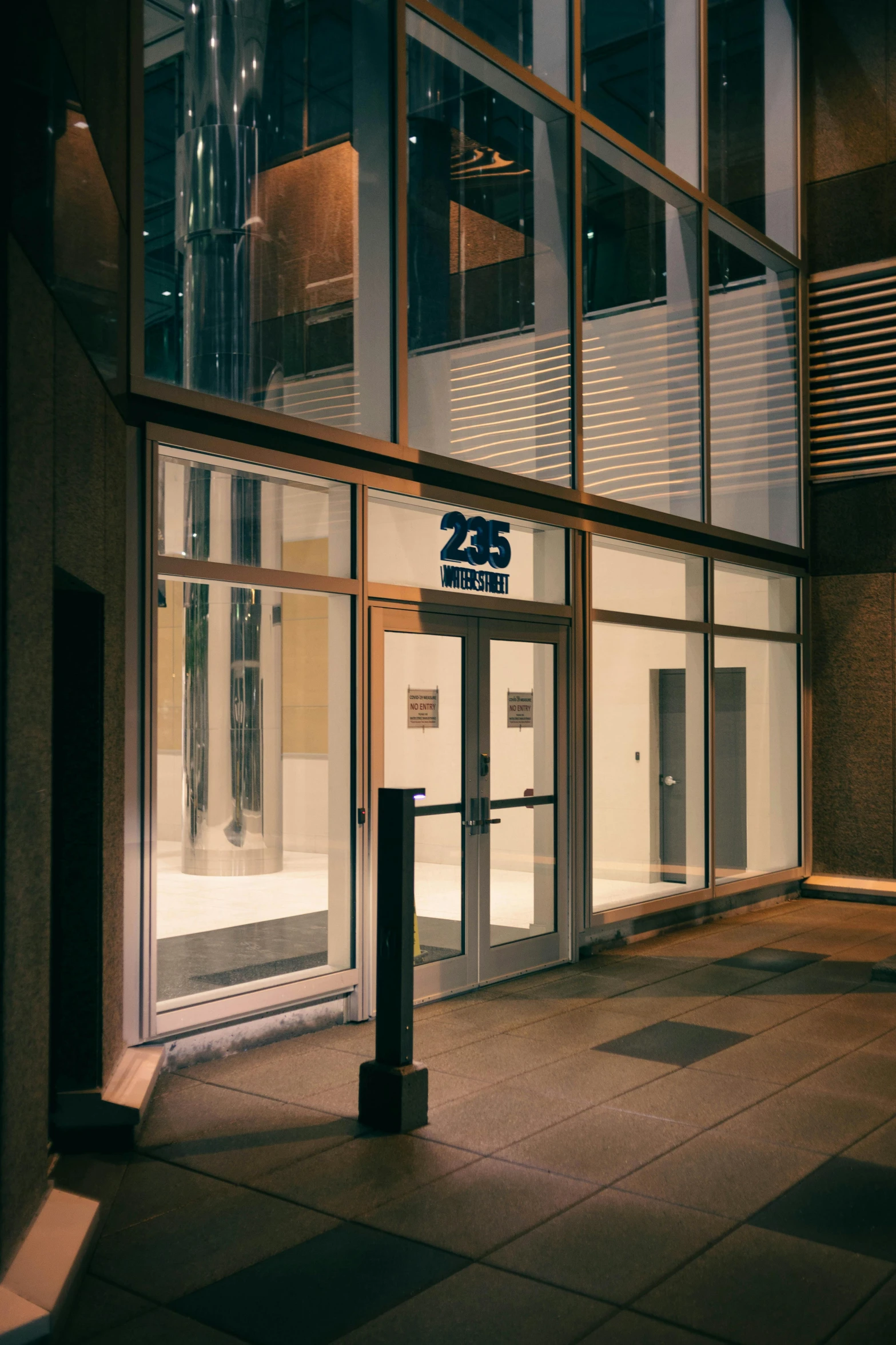 an entrance to a building at night with a sign on it