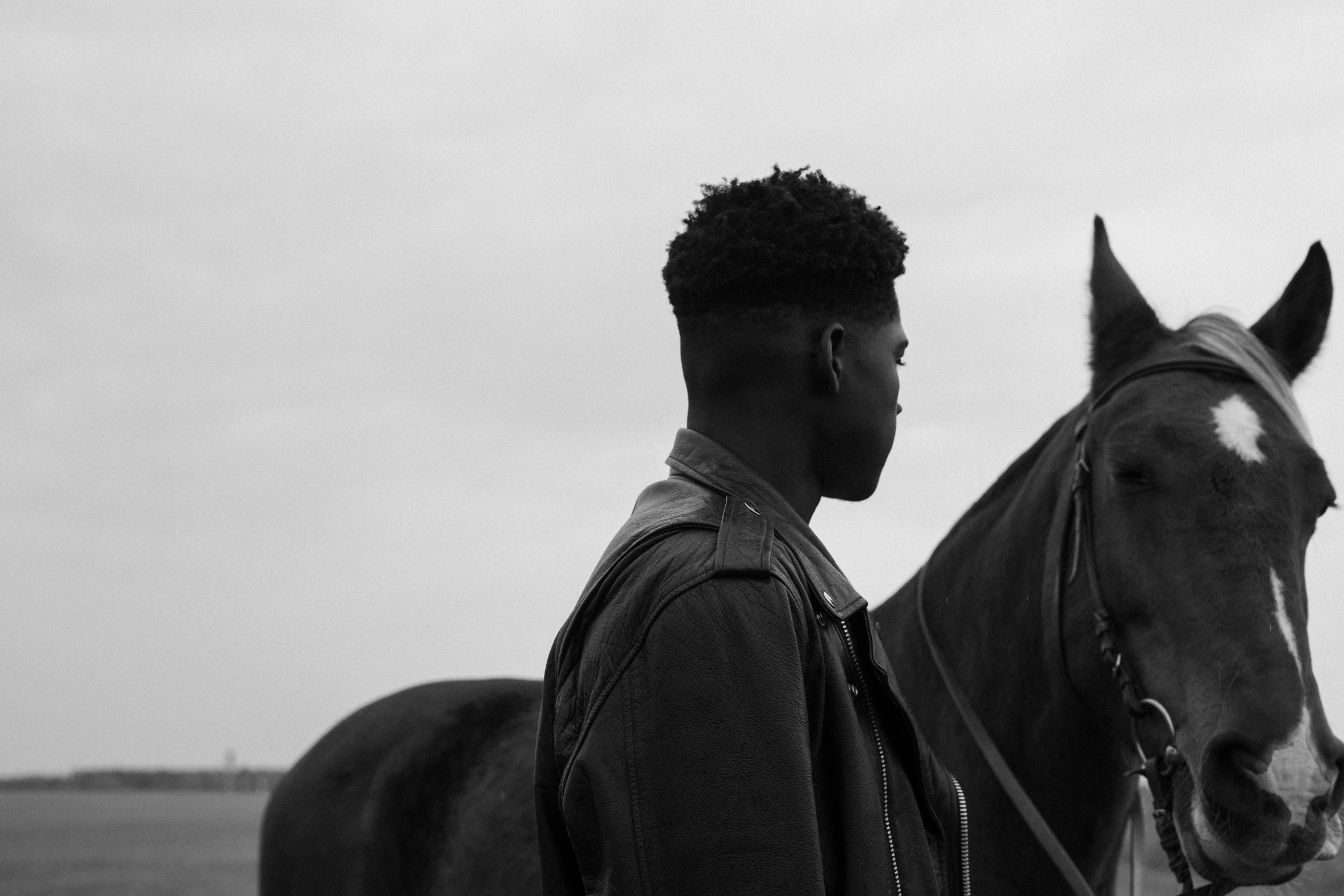 a man standing next to a horse with his arm around the horse