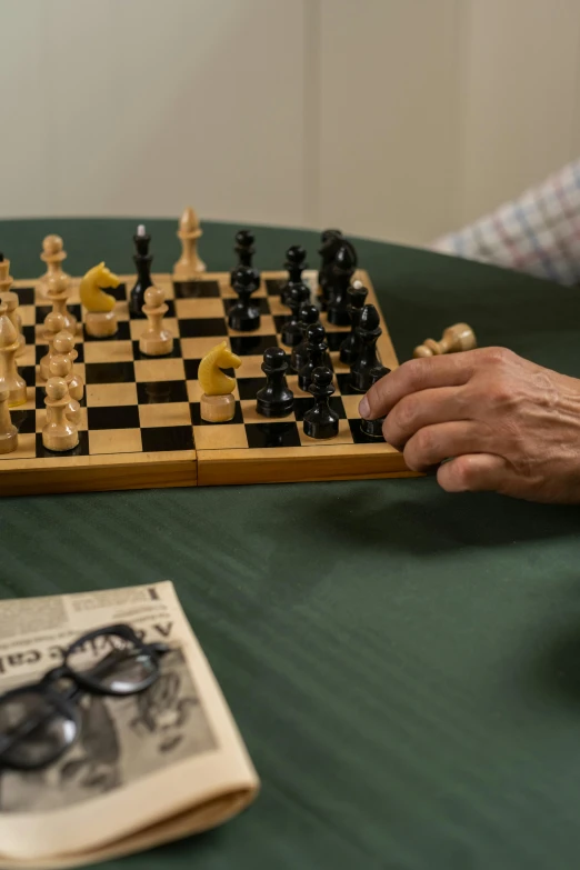 person taking a move of chess piece with magazine