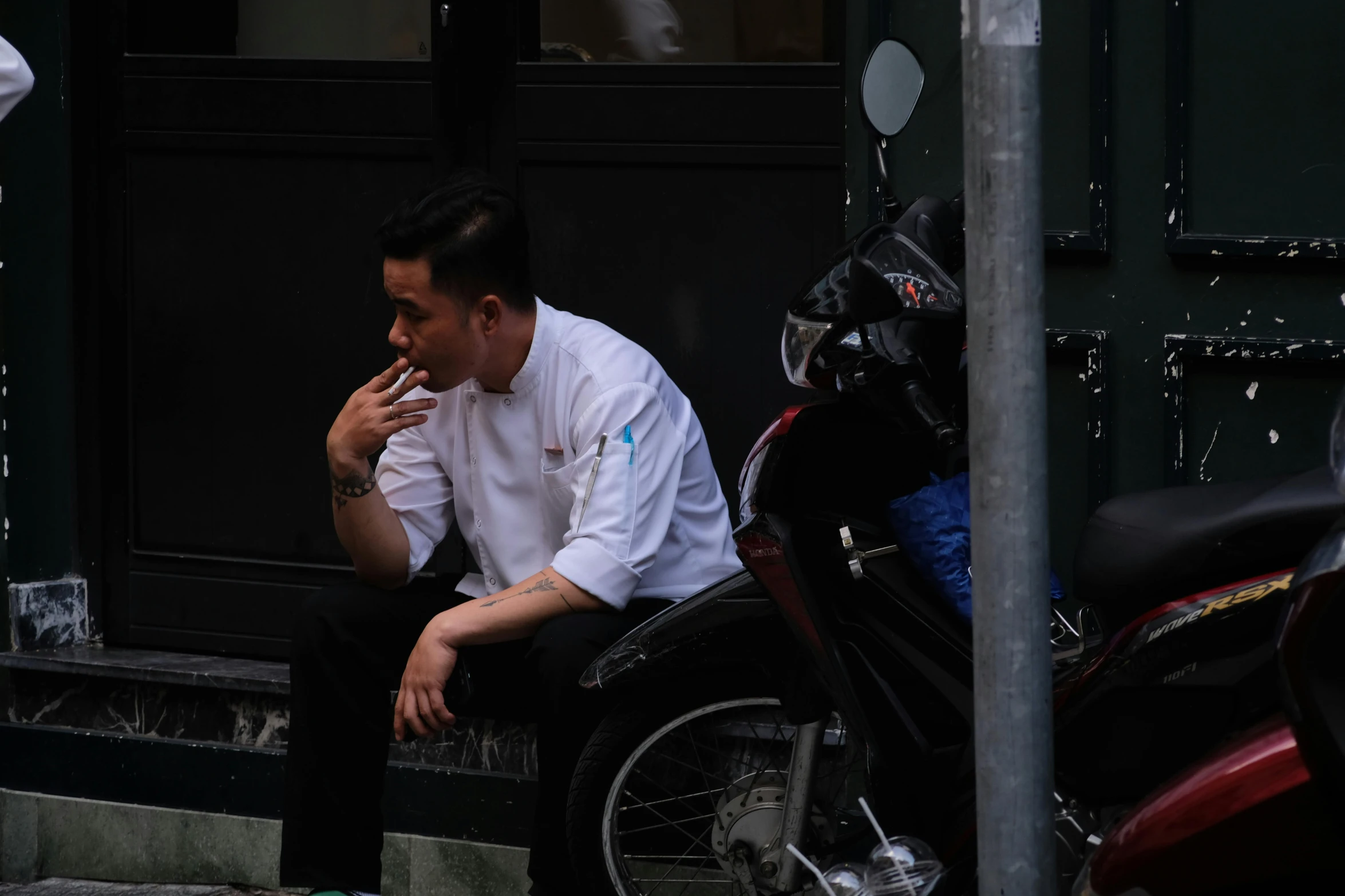 a man sitting on top of a black motorcycle