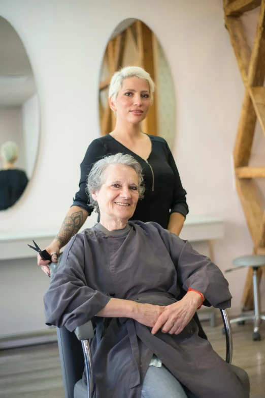 an older woman sits in a hair salon chair