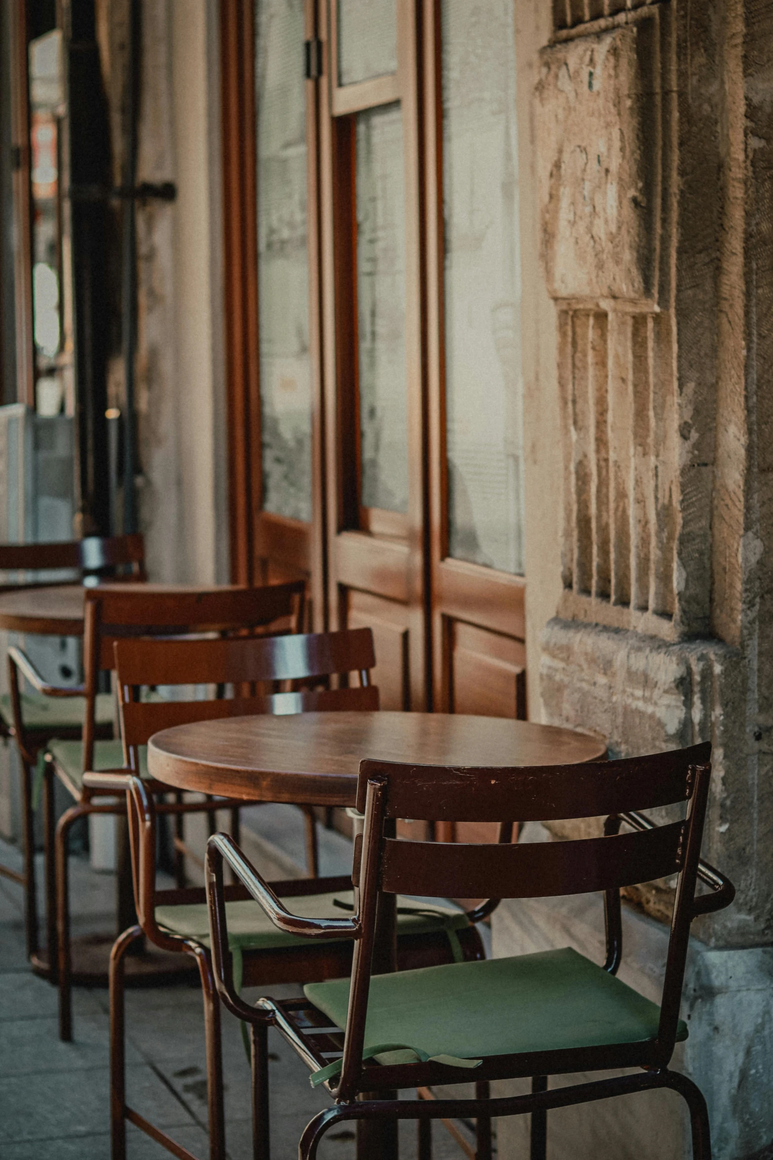 wooden chairs and tables lined up on the side of the road