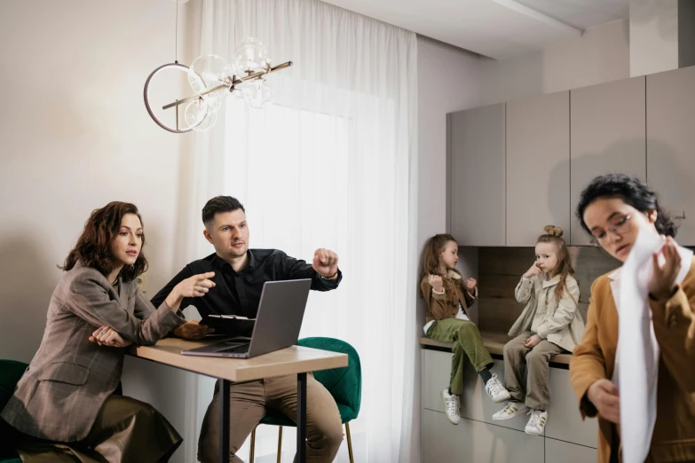 people in a kitchen are sitting at a table