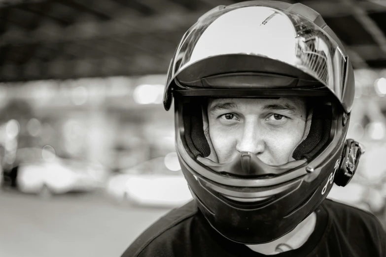 a black and white image of a person wearing a motorcycle helmet