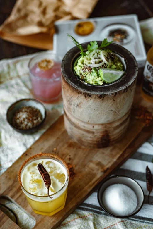 two alcoholic beverages are on a wooden platter