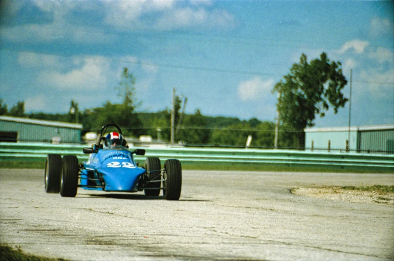 a blue race car in the process of rounding