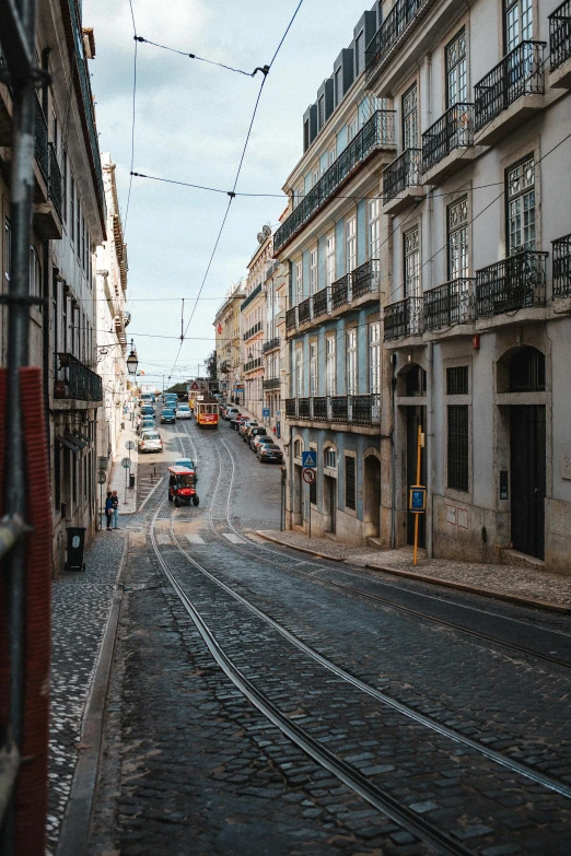 a city street with various buildings and tracks running through it