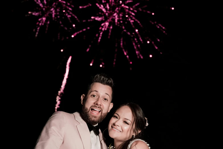 a man and woman are taking a po with their wedding fireworks