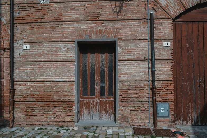 the wooden door is in front of the brown building