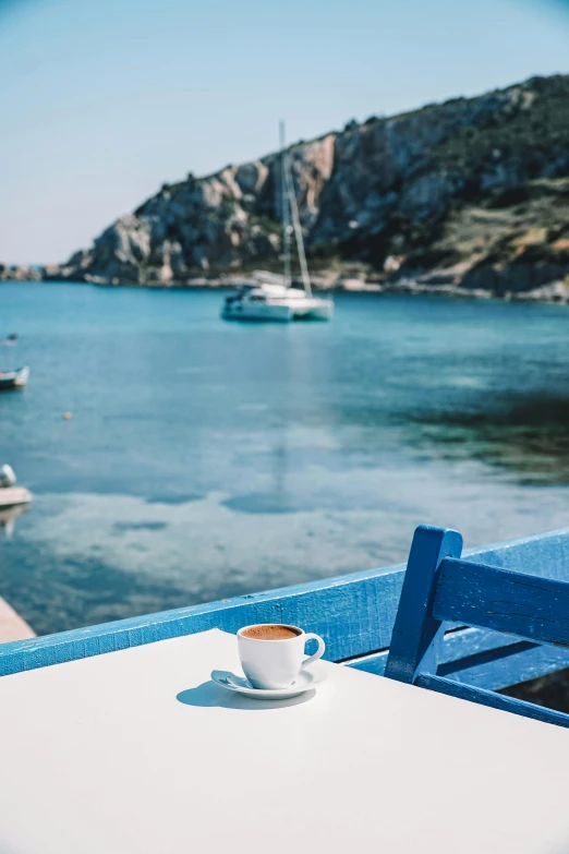 a cup of coffee on a table next to boats