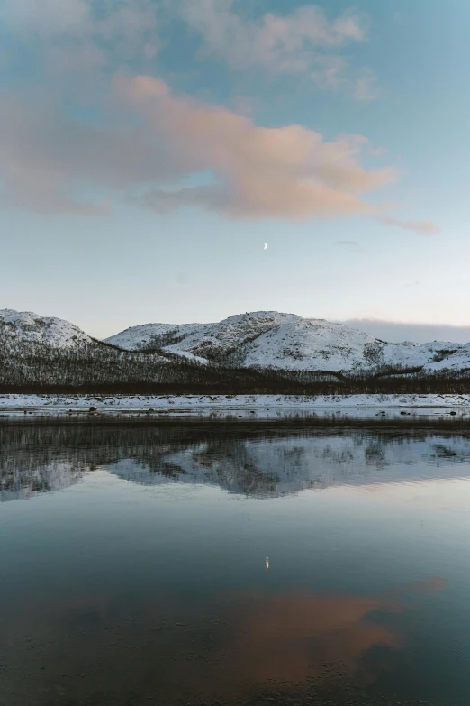 a large mountain covered in snow next to water