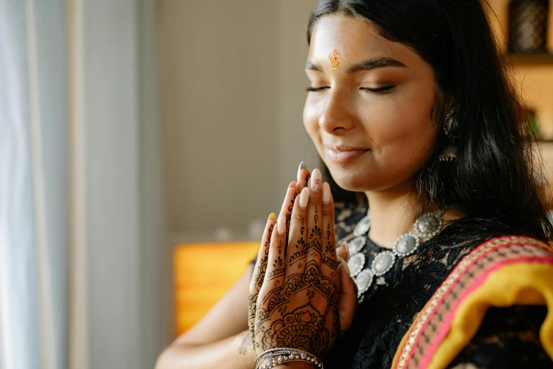 woman in indian clothing putting her hands together