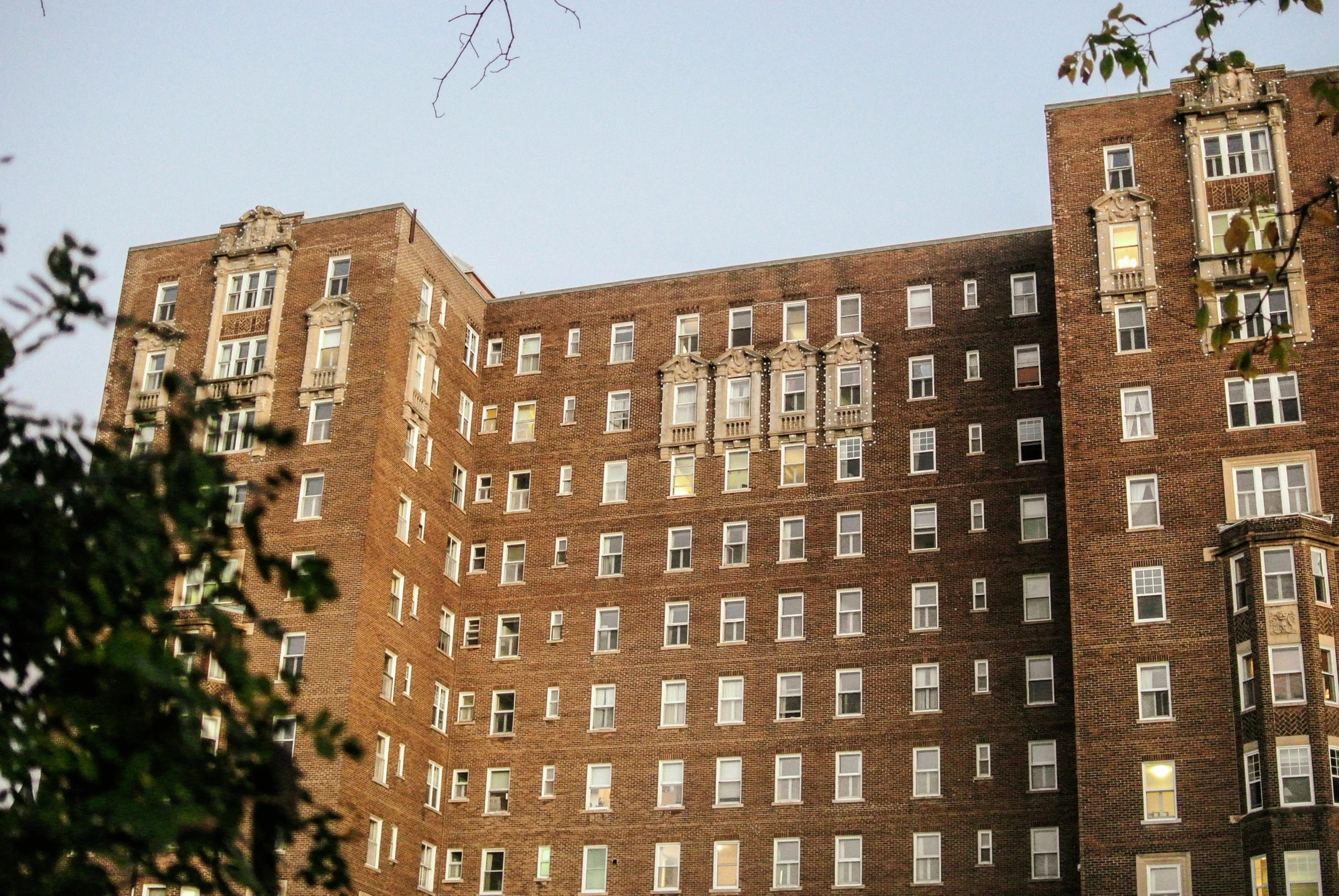 an old, brown building is surrounded by green trees