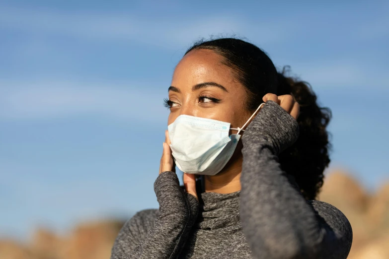 a woman is wearing a white face mask to protect her from corona disease