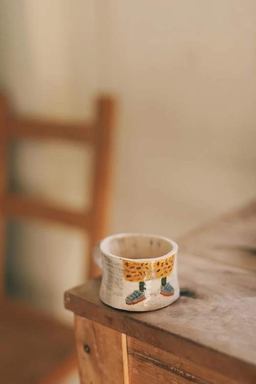 an empty cup sitting on top of a wooden desk